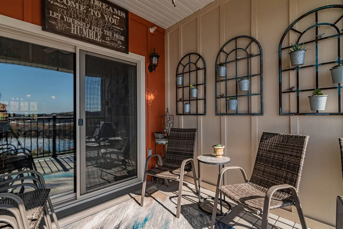 A tranquil exterior patio with comfortable textured seating, decorative wall planters, and a stunning view of the water, inviting relaxation and conversation outdoors.