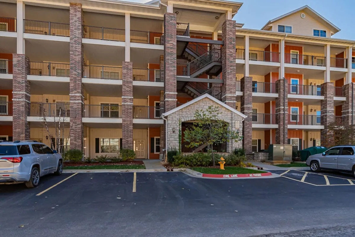 This image captures the exterior of the property, showcasing attractive architecture, manicured landscaping, the welcoming front entrance, and a convenient parking area. The scene conveys a sense of arrival and connection to the surrounding environment, suggesting opportunities for group gatherings and easy access to local attractions.